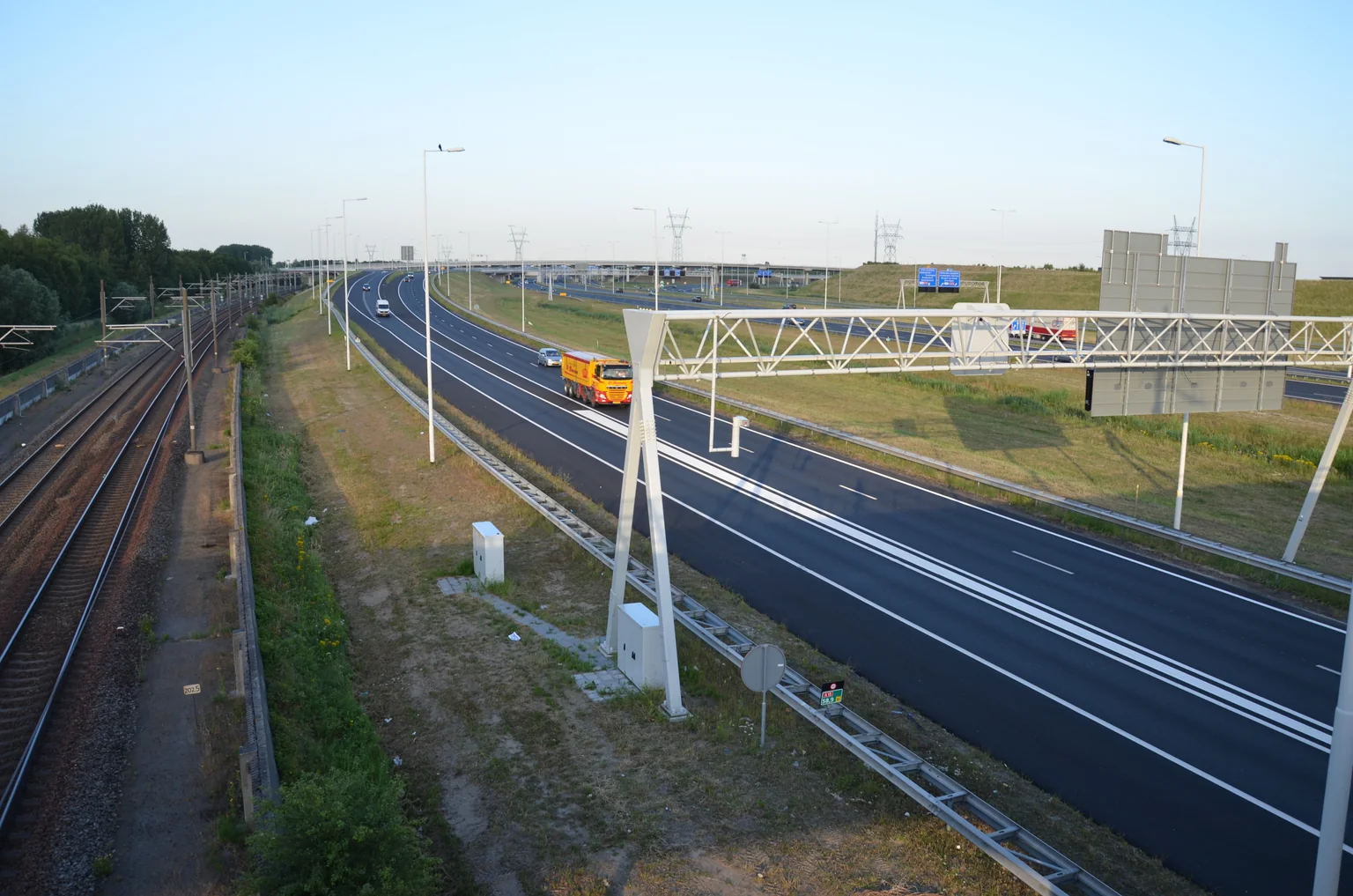 Verkeer op de A15 bij Rotterdam, met het spoor naast de weg, in juli 2015