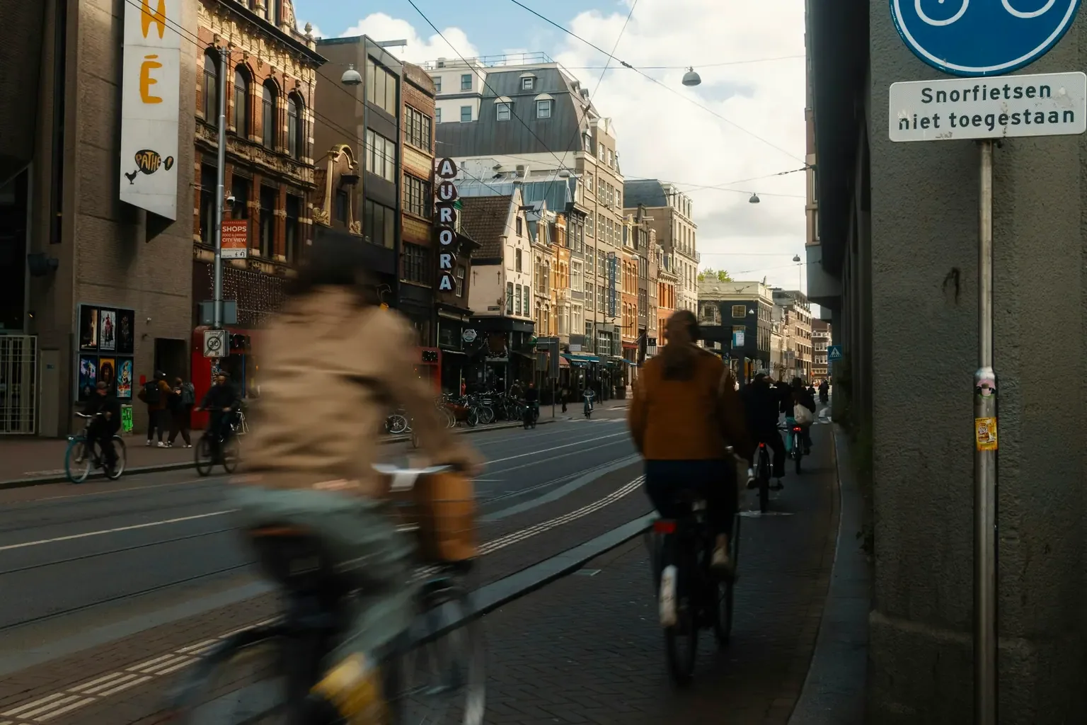Fietsers rijden langs elkaar door een Amsterdamse straat, met beweging in het beeld