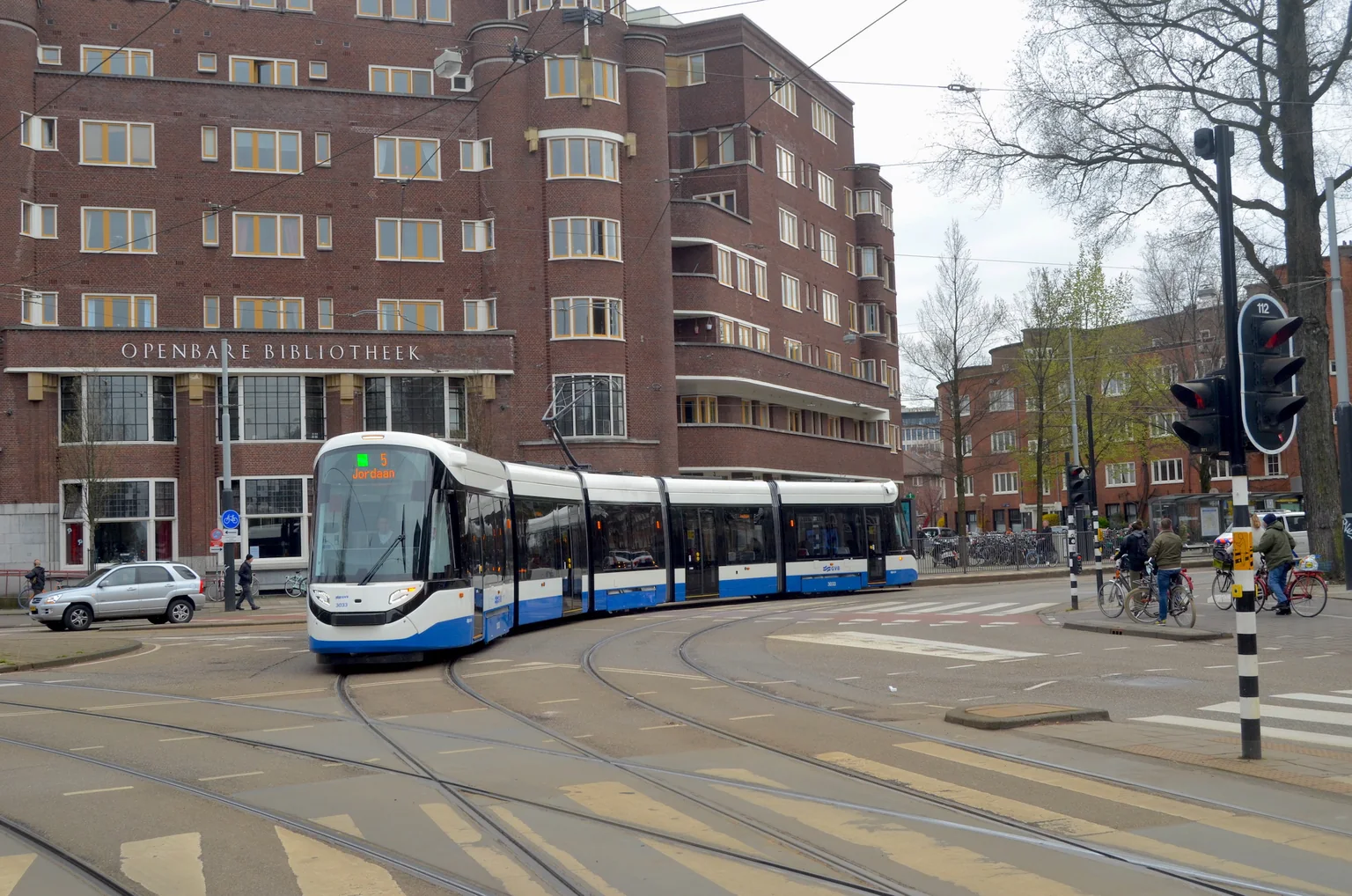 Een blauw-witte GVB-tram rijdt over het Roelof Hartplein in Amsterdam in 2021