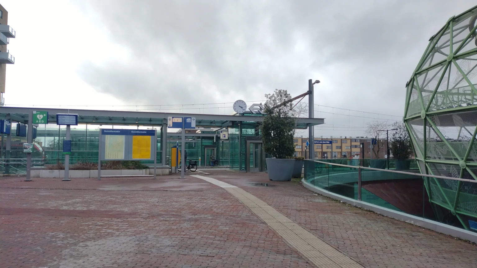 De ingang van station Alphen aan den Rijn met rechts de Fietsappel, gefotografeerd in februari 2023